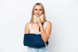 Confused woman with a neck and arm brace looking unsure of what to do about her personal injury